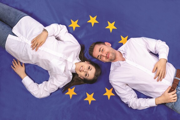 Chłopak i dziewczyna na tle flagi Unii Europejskiej