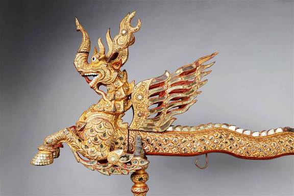 Wizerunek smoka ze rozpostartymi skrzydłami, wykonany z metalu.