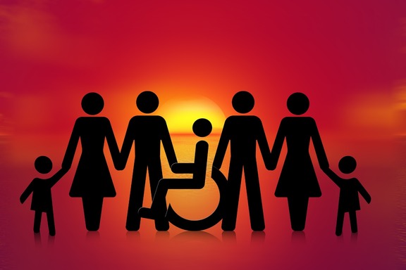 Sylwetki kobiet i mężczyzn na kontrastowym tle, op środku wózek inwalidzki