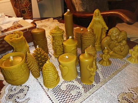  Na stole stoi kilknaście świec z wosku pszczelego w różnych kształtach i rozmiarach. 