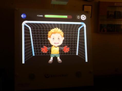 widok na ekran gry komputerowej, widać piłkarza stojącego w bramce