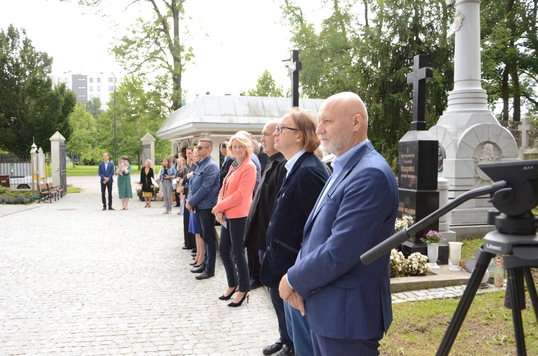 Grupa elegancko ubranych osób stoi przed cerkwią, czeka na uroczystość wręczenia ceryfikatów 
