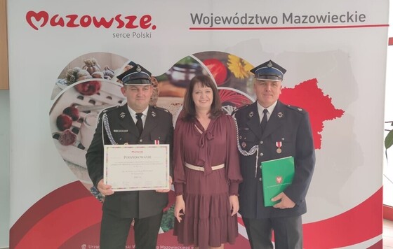 Janina Ewa Orzełowska i dwóch strażaków