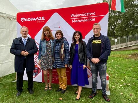 Premier dr Reiner wraz z czterema przedstawicielami Mazowsza pozuje do zdjęcia na tle baneru województwa