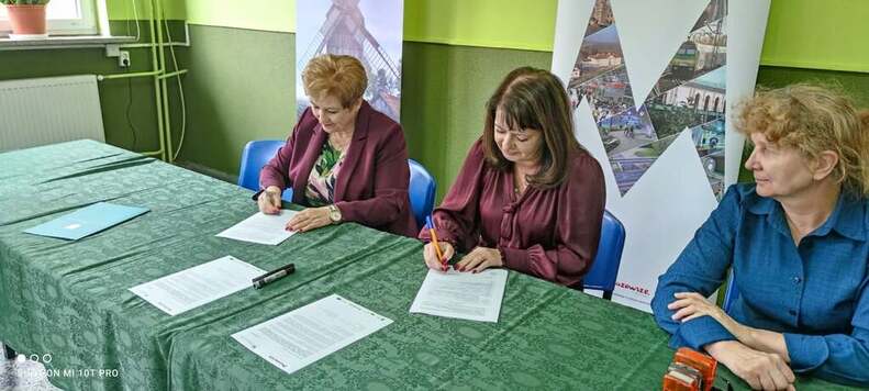 Dwie kobiety podpisują umowy