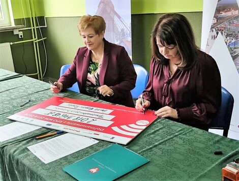 Dwie kobiety podpisują symboliczny czek