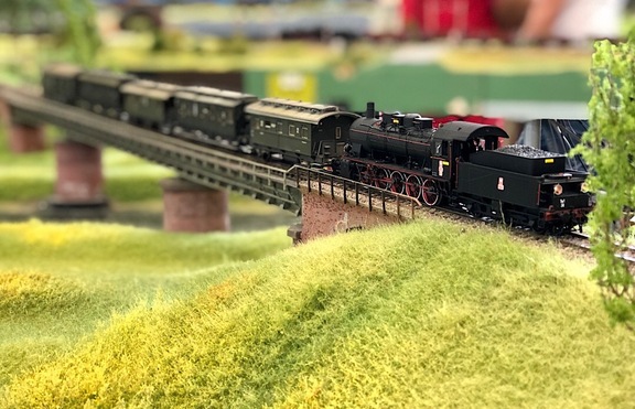 miniaturowy model pociągu przejeżdżający przez wiadukt