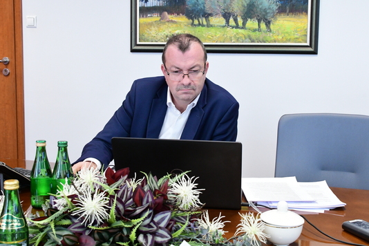Wicemarszałek Wiesław Raboszuk siedzi przy stole przed otwartym laptopem
