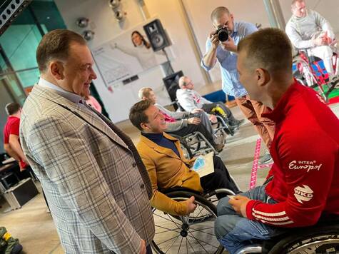Marszałek rozmawia ze sportowcem na wózku inwalidzkim