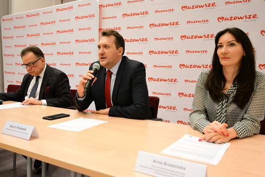 Przewodniczący Marcin Podsędek mówi do mikrofonu