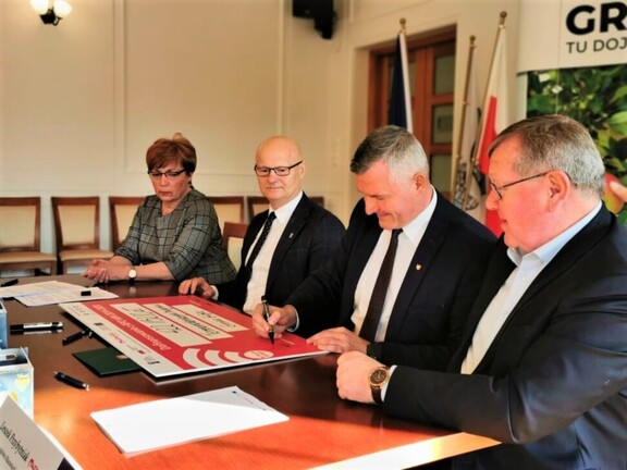 Wicemarszałek Rafał Rajkowski podpisuje symboliczny czek z kwotą dofinansowania