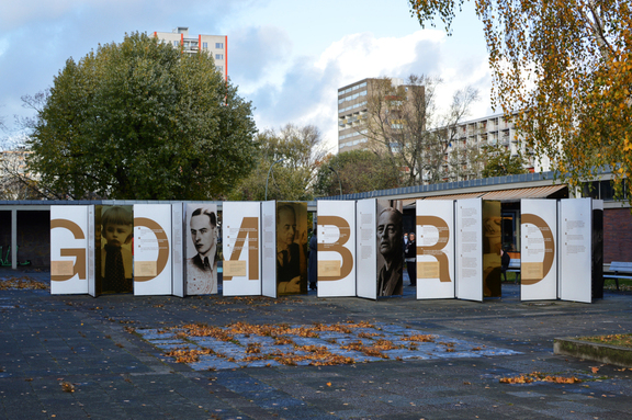 wielkie plansze ze zdjęciami i tekstem ustawione są w przestrzeni miejskiej Berlina