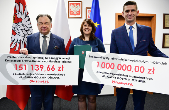 Marszałek oraz dwóch przedstawicieli gminy Gołymin-Ośrodek pozują do zdjęcia z dwoma czekami