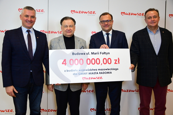 Marszałek, wicemarszałek, radny i prezydent Radomia pozują do zdjęcia z czekiem