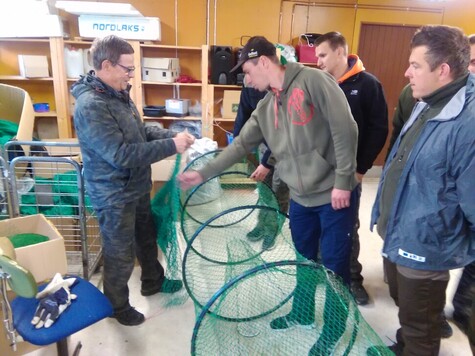 Kilku mężczyzn szkoli się z metod wykorzystania sieci do połowu ryb