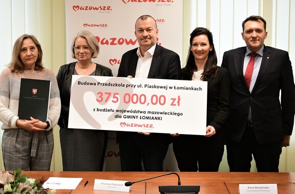 Wicemarszałek Raboszuk, radna Brzezińska, burmistrz i skarbnik Łomianek pozują do zdjęcia z czekiem