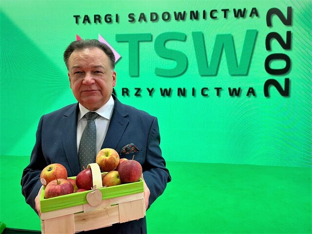 Marszałek Adam Struzik trzyma łubiankę pełną jabłek