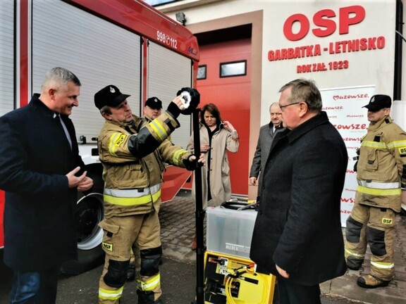 Strażak pokazuje wicemarszałkowi Rajkowskiemu i radnemu Przybytniakowi jeden z zakupionych sprzętów