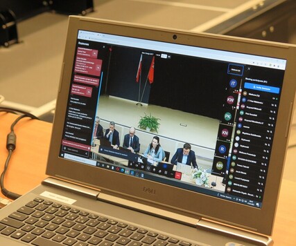 Widok na otwarty monitor laptopa, na którym pokazani są członkowie sejmikowej komisji, biorący udział w spotkaniu stacjonarnie