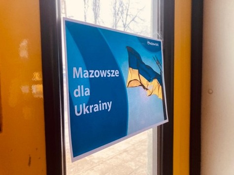 Kartka z napisem Mazowsze dla Ukrainy i flagą Ukrainy na szybie pociągu.