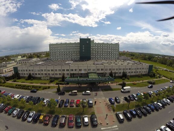 Widok na radomski szpital z lotu ptaka. Widać wielki gmach szpitala i zapełnione parkingi przed nim