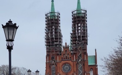 Widok na kościół od frontu. Dwie kościelne wieże są obudowane rusztowaniami.