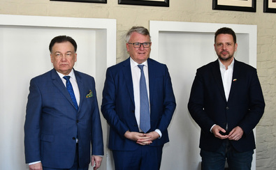 Marszałek Adam Struzik, komisarz Nicolas Schmit i prezydent Warszawy Rafał Trzaskowski stoją obok siebie i pozują do zdjęcia.