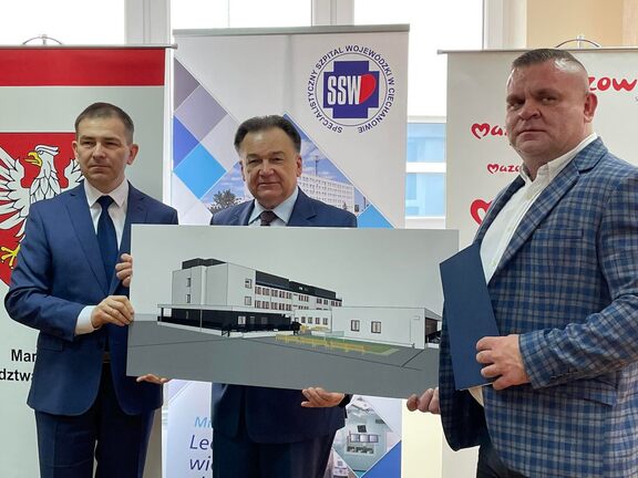 Strony spotkania trzymają wizualizację projektu rozbudowy  oddziału zakaźnego Specjalistycznego Szpitala Wojewódzkiego w Ciechanowie.