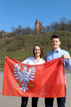 mężczyzna i kobieta trzymają w rękach flagę Mazowsza