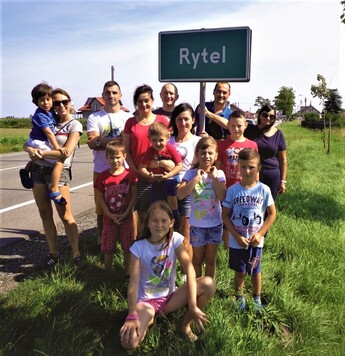 Rodzina pod tablicą z nazwą miejscowości Rytel