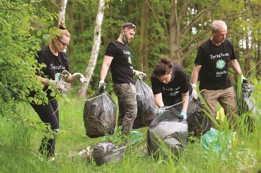 Zdjęcie przedstawia zespół Fundacji Nasza Ziemia sprzątający Lasek Brodnowski.
