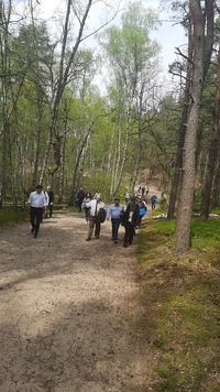 Członkowie spotkania idą przez las leśną ścieżką