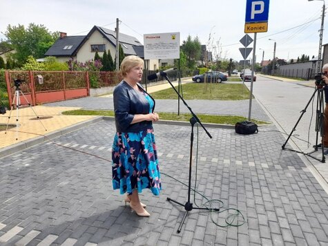 Elżbieta Lanc stoi na chodniku przed mikrofonem