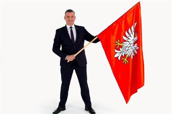 Wicemarszałek Rafał Rajkowski z dumą pokazuje flagę Mazowsza.