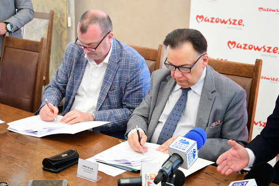 Na zdjęciu dwóch mężczyzn podpisują umowę