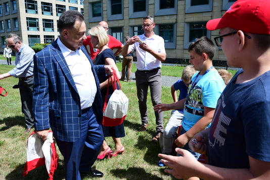 Marszałek Adam Struzik rozdaje dzieciom torby z gadżetami