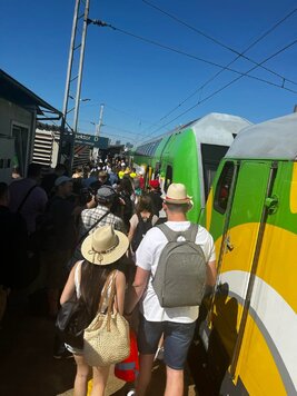 Na zdjęciu duża grupa ludzi wsiadająca do pociągu