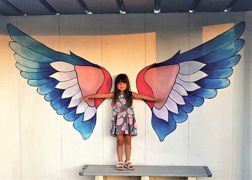 Dziecko na przystanku ze skrzydłami