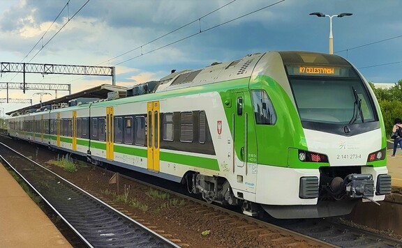 Pociąg w zielono-żółto-białych barwach mazowieckiego przewoźnika stoi na torach, gotowy do drogi.