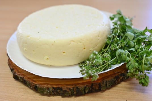 Bochen sera na talerzy przyozdobiony zieleniną