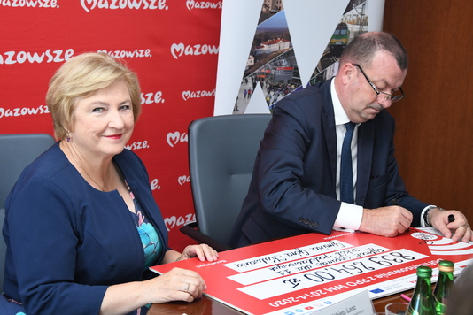 Wicemarszałek Wiesław Raboszuk i członkini zarządu Elżbieta Lanc podpisują pamiatkowy czek 