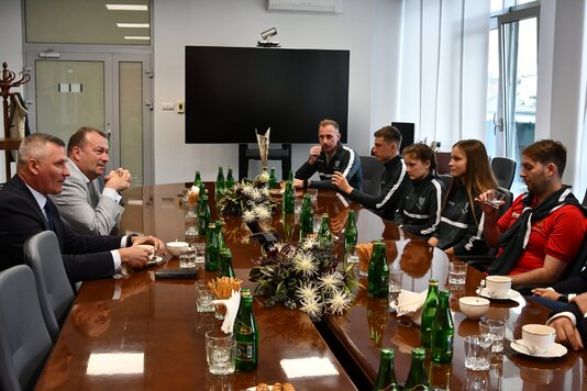 Przy owalnym stole w sali konferencyjnej siedzą wicemarszałkowie Rajkowski i Raboszuk oraz przedstawiciele dwóch druużyn piłkarskich - chłopców i dziewcząt