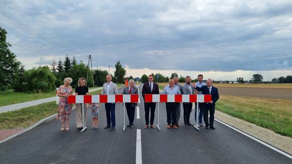 W poprzek pustej drogi asfaltowej stoją w rzędzie dyrektor Kominek, przedstawiciele gmin Bielsk i Baranowo oraz Mazowieckiego Zarządu Dróg Wojewódzkich