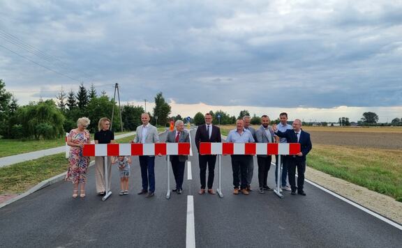W poprzek pustej drogi asfaltowej stoją w rzędzie dyrektor Kominek, przedstawiciele gmin Bielsk i Baranowo oraz Mazowieckiego Zarządu Dróg Wojewódzkich