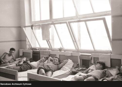 dzieci odpoczywające na łóżkach w wieloosobowej sypialni na koloniach