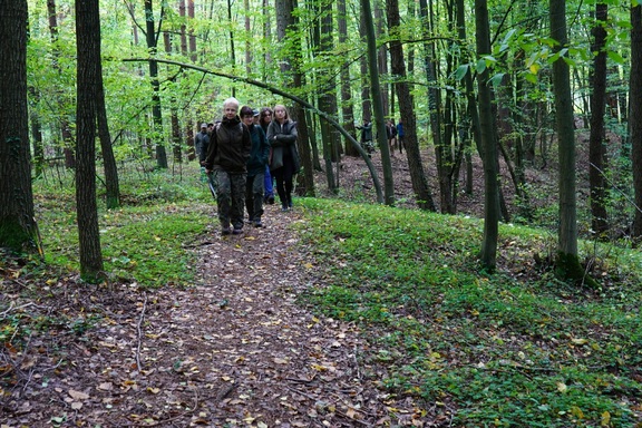 Grupa ludzi idzie ścieżką przez las