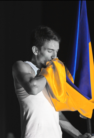 zdjęcie sportowca całującego z szacunkiem ukraińską flagę