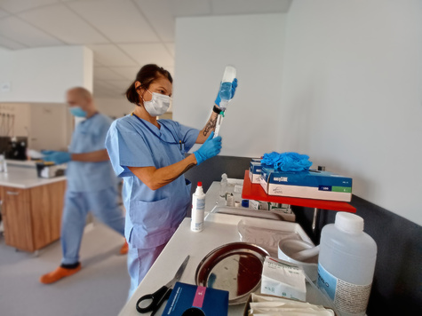 pielęgniarka nabiera do strzykawki płyn z plastikowej butelki 