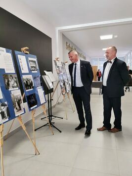 Wicemarszałek Rajkowski ogląda wystawę zdjęć na szkolnym korytarzu