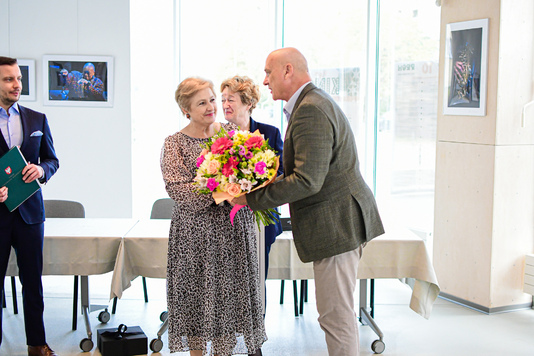 Elżbieta Lanc otrzymuje bukiet kwiatów od mężczyzny.